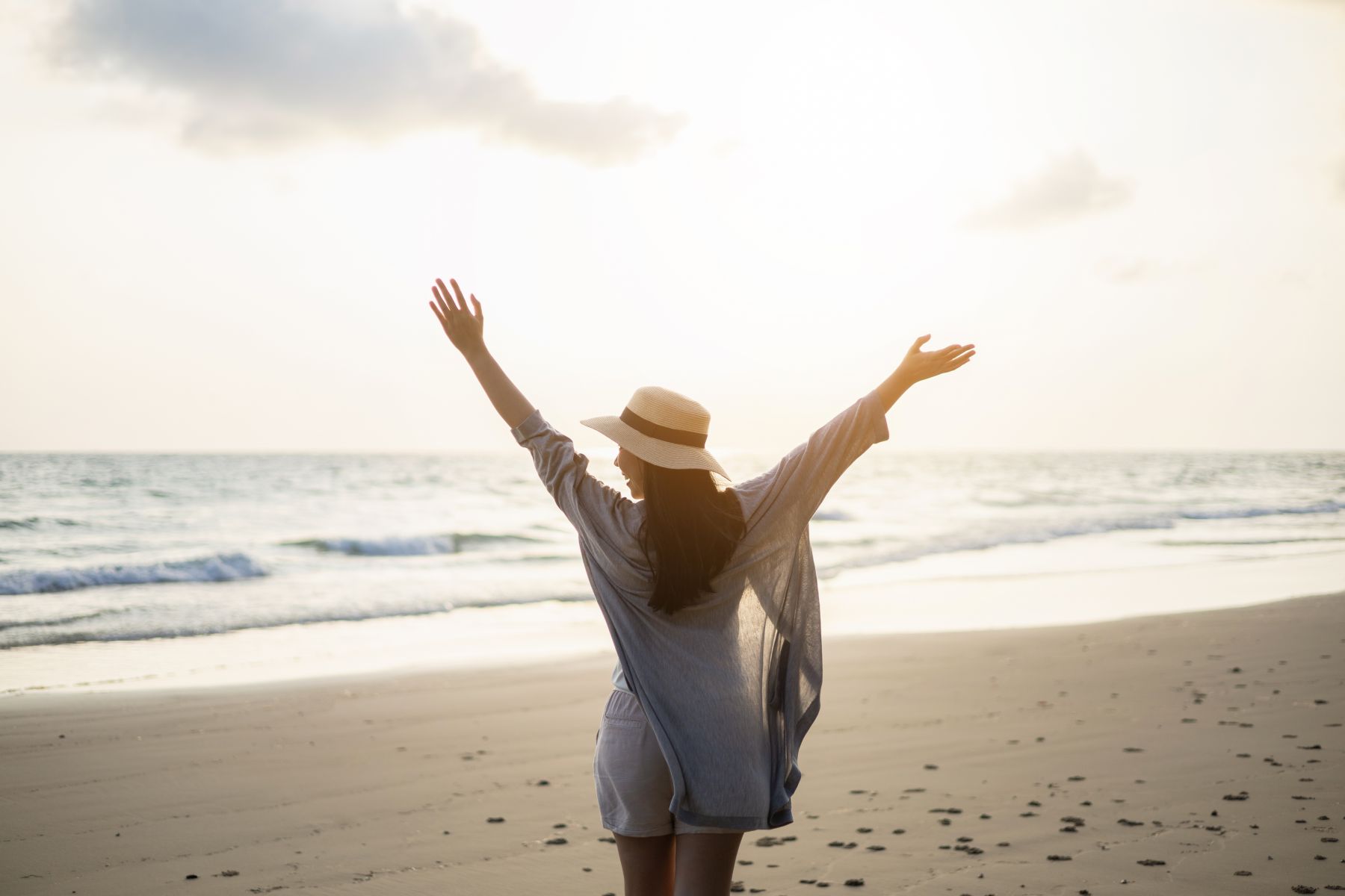 woman standing on the beach at sunset